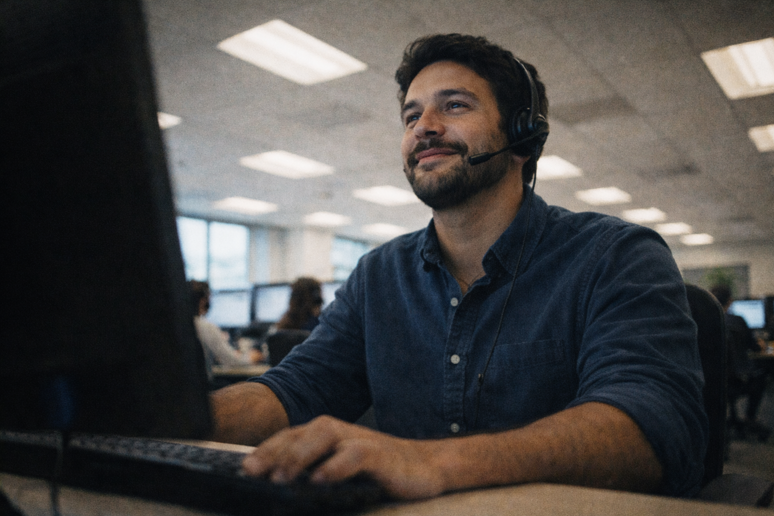 Care coordinator with headset at a computer, supporting people navigating care and resources